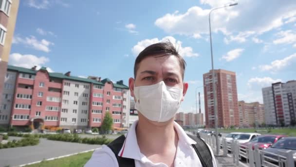 顔の保護医療マスクの若者が街を歩き回ってる。隔離コロナウイルス - 映像、動画
