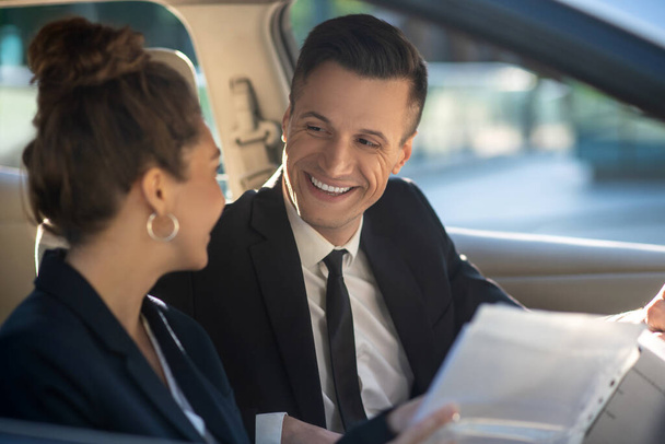 Man and woman conducting business negotiations in a car - Foto, Imagen