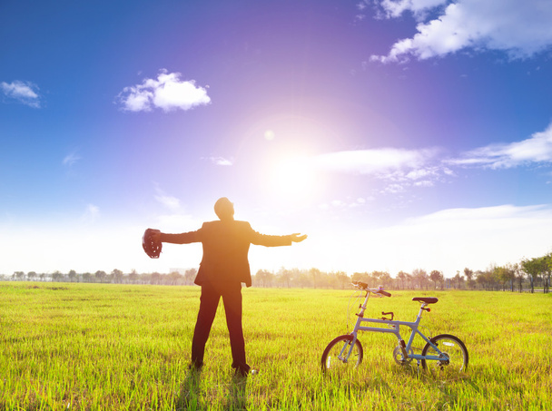 бізнесмен розслабляється в зеленій землі і сонці з велосипедом
 - Фото, зображення