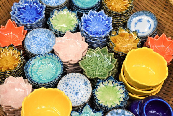 Kulaté a květinové porcelánové talíře a mísy v různých barvách a provedeních - Fotografie, Obrázek