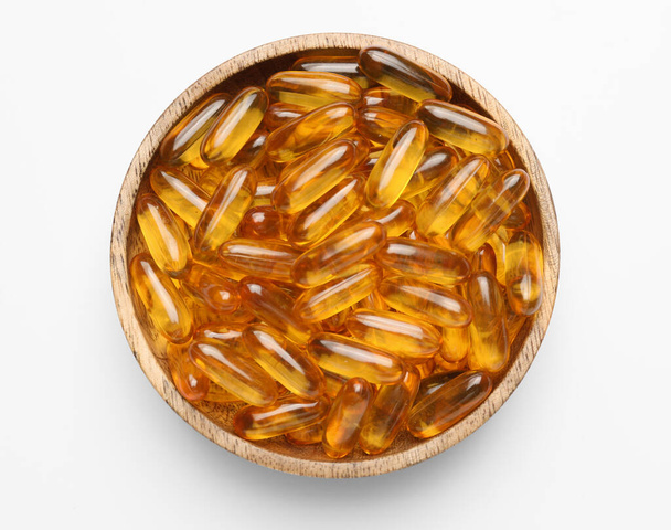 Teller mit Fischöl-Kapseln auf weißem Hintergrund - Foto, Bild