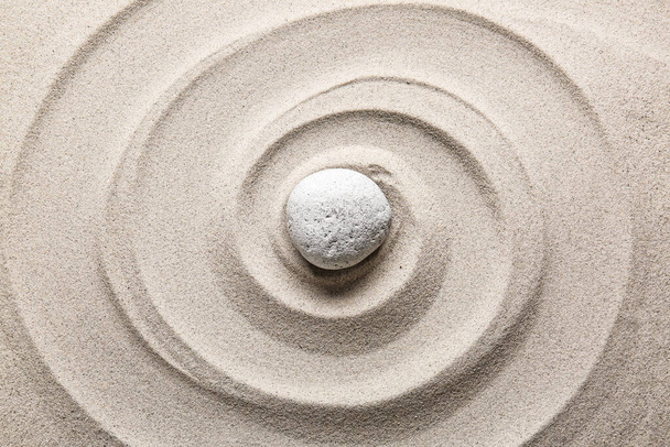 Kamień na piasku z liniami. Koncepcja zen - Zdjęcie, obraz