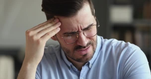 Unhealthy young businessman suffering from strong headache. - Video, Çekim
