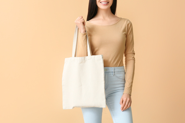 Young woman with eco bag on color background - Фото, зображення