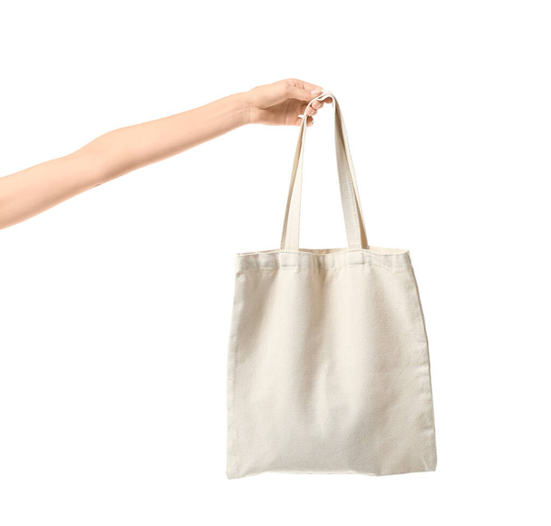Γυναικείο χέρι με οικολογική τσάντα σε λευκό φόντο - Φωτογραφία, εικόνα