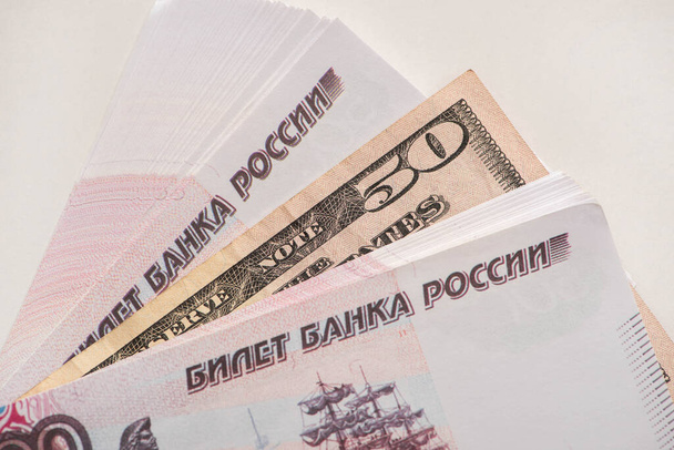 πάνω όψη ρωσικών ρουβλίων και χαρτονομισμάτων δολαρίου που έχουν απομονωθεί σε λευκό - Φωτογραφία, εικόνα