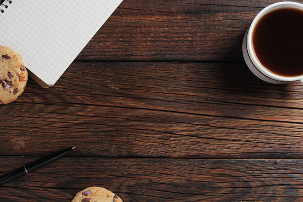 Xícara de café, biscoitos e notebook sobre fundo de madeira, vista superior witn espaço de cópia
 - Foto, Imagem