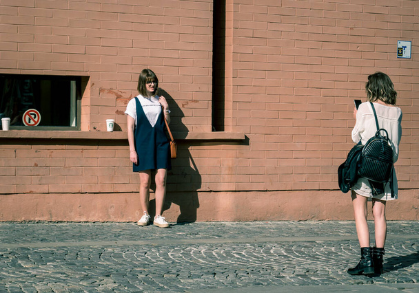 Bukareszt / Rumunia - 05.30.2020: Dwie dziewczyny na starówce Bukaresztu. robienie sobie zdjęć lub pozowanie do siebie. - Zdjęcie, obraz