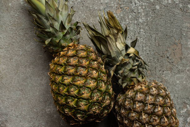 top view of ripe pineapples on grey concrete surface - Photo, Image