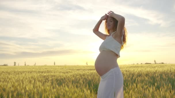 Zwangere moeder dansend. Onderwerp Zwangerschap en Moederschap. Schattig en leuk mama dansen op zonsondergang. - Video