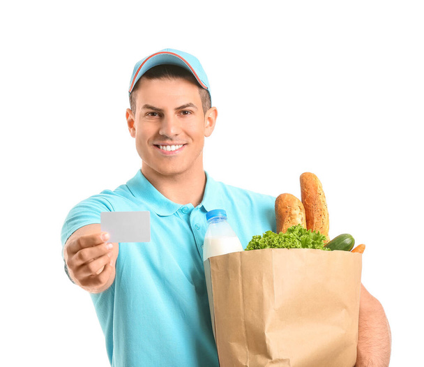 Delivery man with food in bag and business card on white background - Photo, Image