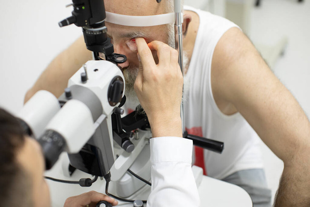Senior patient checking vision with special eye equipment - Valokuva, kuva
