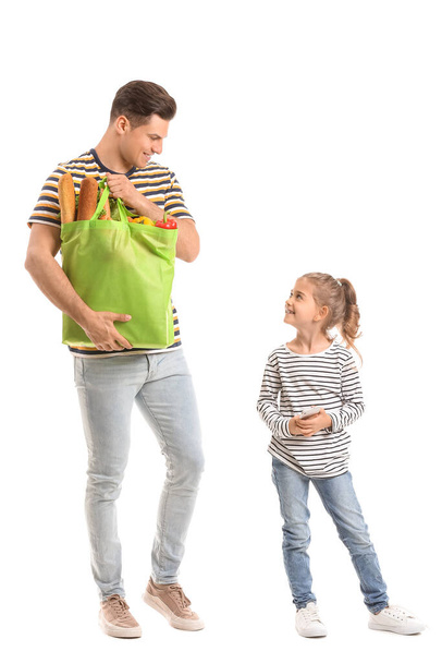 Father and daughter with food in bag and mobile phone on white background - Foto, afbeelding