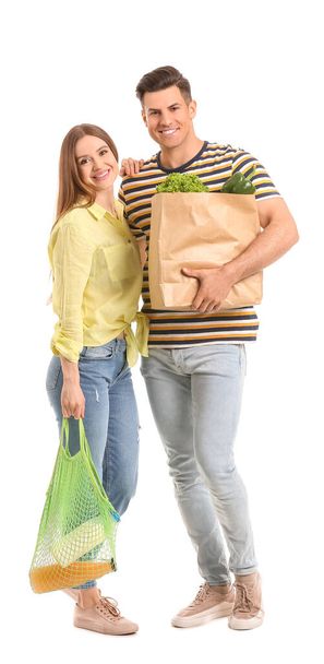Couple with food in bags on white background - Φωτογραφία, εικόνα