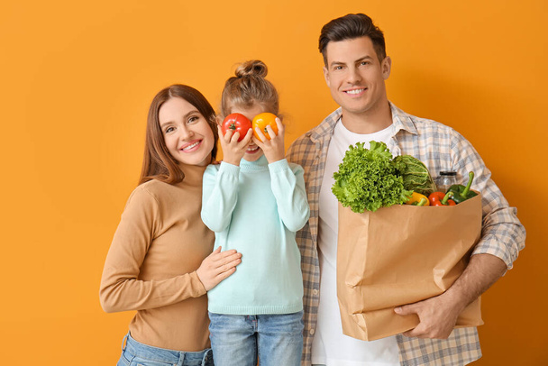 Familie mit Essen in Tüte auf farbigem Hintergrund - Foto, Bild