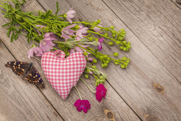 Літнє натюрморт з букетом рожевої мальви і серцем на дерев'яному фоні
 - Фото, зображення