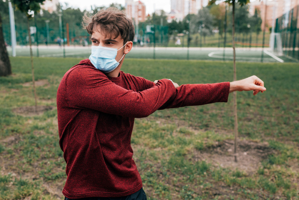 Sportsman in medical mask training in park  - Fotó, kép