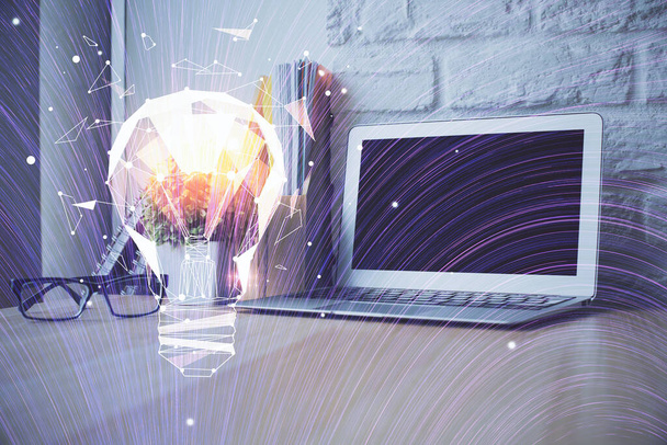 Computer on desktop in office with bulb icon hologram. Double exposure. Concept of idea. - 写真・画像
