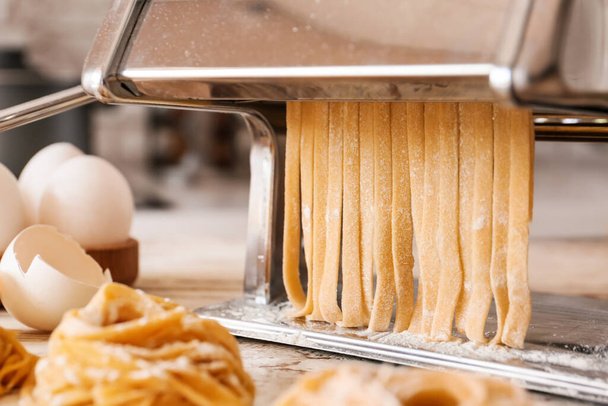 Preparing of pasta with machine on kitchen table - Valokuva, kuva
