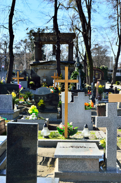 Groby i kwiaty na cmentarzu katolickim. - Zdjęcie, obraz