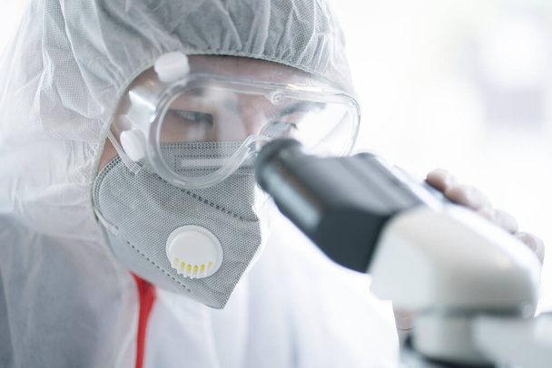 Medical scientist analyzing microscope slides in research lab for 2019-nCoV vaccine or serum. - Φωτογραφία, εικόνα