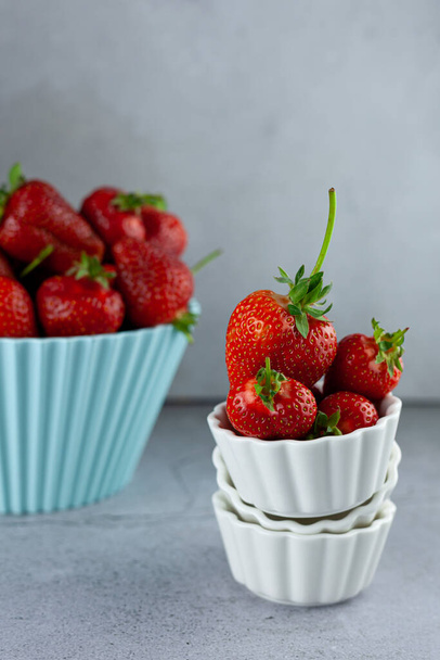 Bowl of strawberries on the kitchen table. Berries in a white plate. Strawberry crop. Food still life. Red summer berry. Vitamin breakfast. - Foto, Imagem