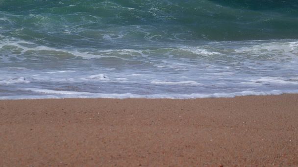 Хвиля на піщаному узбережжі. Зображення мальовничої хвилі, що миє берег. Крупним планом
. - Фото, зображення