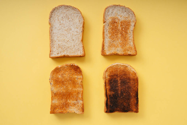 Üst Manzara - 4 tip ızgara yanmış ev yapımı organik dilimlenmiş ekmek sarı arkaplan üzerinde. - Fotoğraf, Görsel