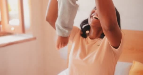Happy mother and little baby son playing together in bed - Filmagem, Vídeo