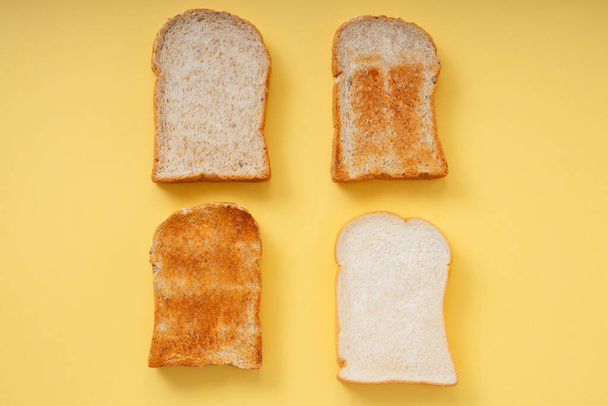 Pohled shora - 4 druhy grilu spálil doma z organických plátků chleba přes žluté pozadí. - Fotografie, Obrázek