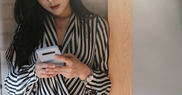 Affari donna asiatica utilizzando smartphone in ufficio
 - Foto, immagini