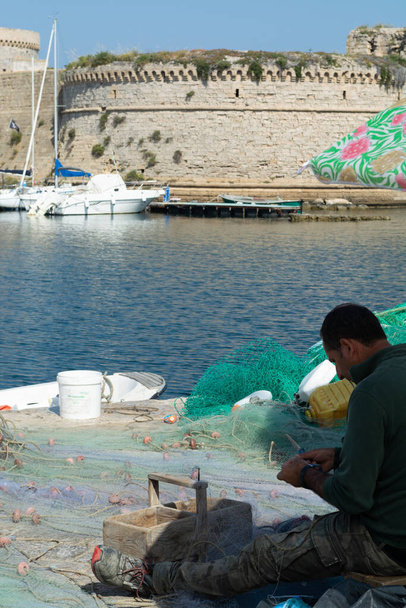 Foto del paisaje matutino hecha en el muelle de Gallipoli, pescadores reparando su red de pescadores después de la pesca, Apulia, Italia
 - Foto, Imagen