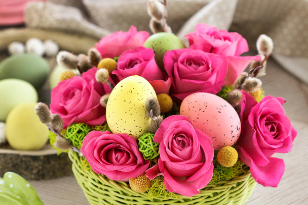 Florist at work: woman shows how to make Easter table decoration with roses, moss and catkins. Step by step, tutorial. - Foto, afbeelding
