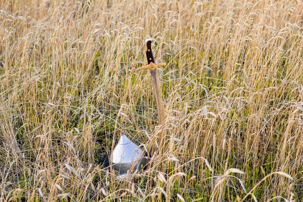 sabre et casque dans un champ de blé - Photo, image