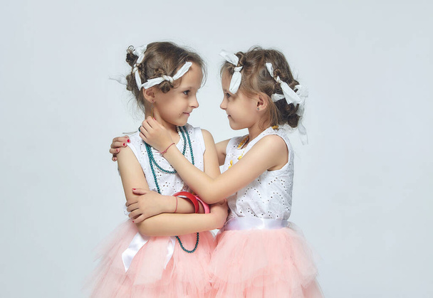two little girls play with their mother's makeup. they pose and try to be adults.Studio, white back - Fotoğraf, Görsel
