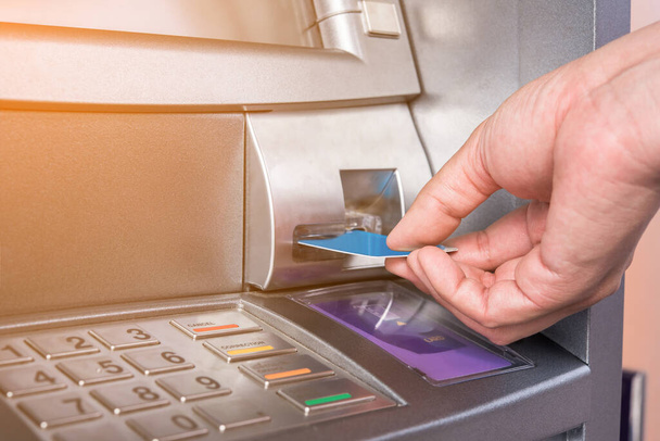Χέρι εισάγοντας την κάρτα ΑΤΜ σε τραπεζικό μηχάνημα για την ανάληψη χρημάτων - Φωτογραφία, εικόνα