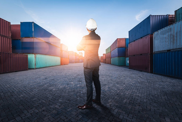 The abstract image of the engineer standing in shipping container yard and copy space. the concept of engineering, shipping, shipyard, business and transportation. - Photo, Image