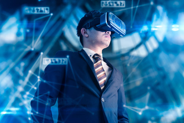aziatische zakenman het dragen van virtuele bril op futuristische achtergrond, innovatie concept  - Foto, afbeelding