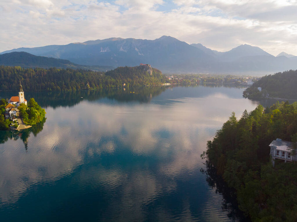 Bled, Szlovénia - A Bled Blejsko Jezero-tó légi panorámás kilátása felülről a Mária Mennybemenetele zarándoktemplommal, a Bled várral és a Julian Alpokkal a háttérben nyáron - Fotó, kép