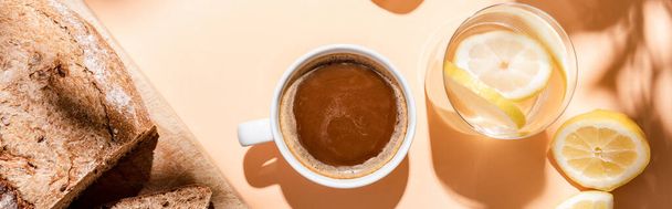 Kahve fincanının üst görüntüsü, kahvaltı için bir bardak su ve ekmek bej masada, yatay görüntü - Fotoğraf, Görsel