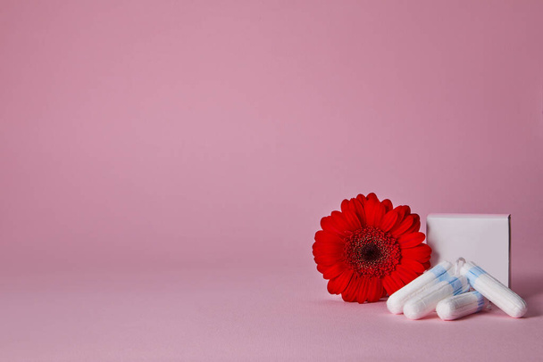 menstrual tampons and red flower isolated on pink background, top view. copy space - Zdjęcie, obraz