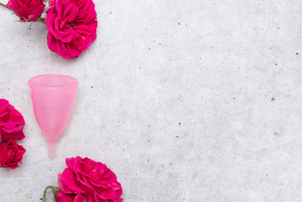 Menstrual cup with flowers on gray background. Menstruation concept - Φωτογραφία, εικόνα
