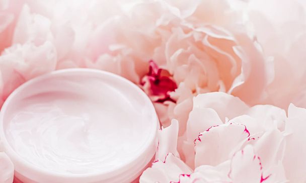 Luxe cosmetische crème pot als anti aging huidverzorging routine product op de achtergrond van pioenroos bloemen, body moisturizer en beauty branding - Foto, afbeelding