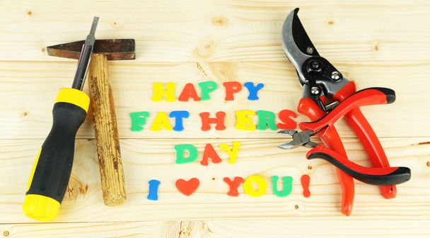 Happy Fathers Day (concept image with multicolor letters and tools, on wooden background) - Photo, Image