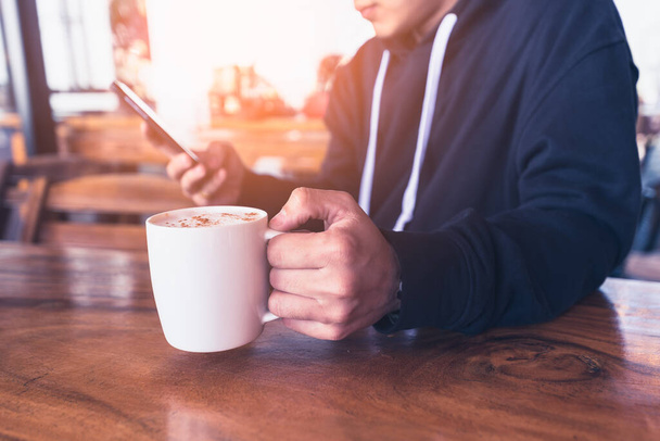 Abstrakcyjny wizerunek biznesmena używającego smartfona w kawiarni. koncepcja zakupów online, płatności online, finansów, freelance, technologii i internetu rzeczy. - Zdjęcie, obraz
