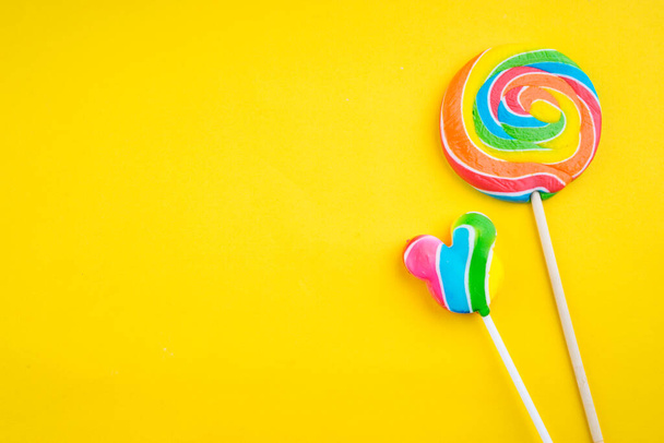 Candies and Sweets concept. Colorful lollipops on vibrant colored background - Photo, Image