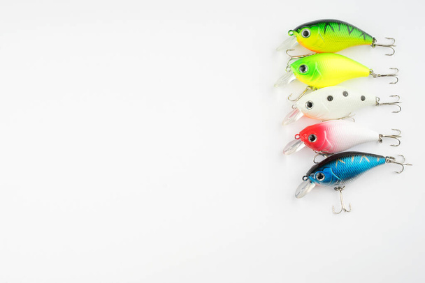 Creative arrangements of wobbler lures. Fishing lure with hooks. Plastic fish with hooks. Flat lay or top view. - 写真・画像
