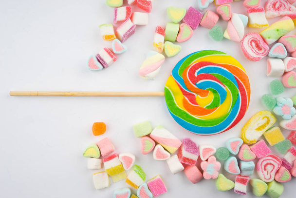 Творческое оформление красочных конфет и сладостей на белом фоне. Плоский вид
. - Фото, изображение
