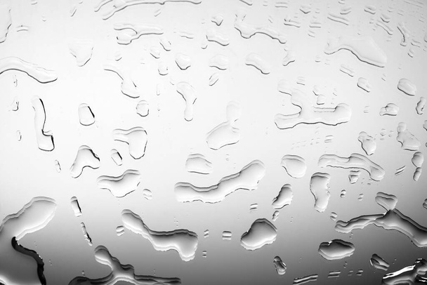 Монохромне зображення дзеркальної скляної поверхні з краплями води, чорно-білим градієнтом, блискучою росою, дощем або рідиною на скляній поверхні, вологим тлом текстури крупним планом
 - Фото, зображення
