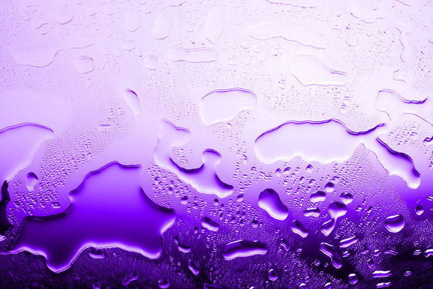 Powierzchnia mokrego szkła z kroplami wody, fioletowy gradient, tekstura rozlanej wody w jasnych kolorach, abstrakcyjne tło, układ, baner, tapeta - Zdjęcie, obraz